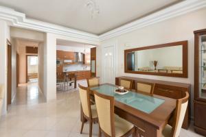 a dining room and kitchen with a table and chairs at Family apartment near the sea in Kremasti