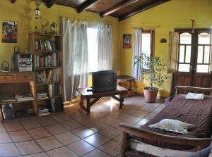 sala de estar con cama y TV en Cabañas Mi Refugio en Villa Giardino