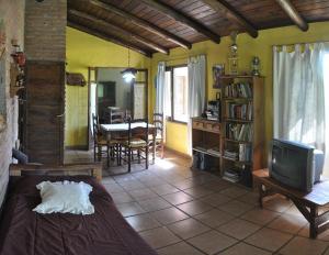 a living room with a tv and a dining room at Cabañas Mi Refugio in Villa Giardino