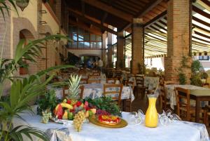 a table with a plate of fruit on it in a restaurant at Camping Bella Italia in Peschiera del Garda