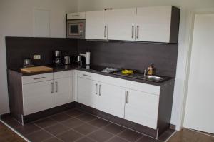 a kitchen with white cabinets and a sink at Ferienwohnung 2 Kormoran in Sagard