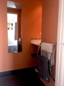 a bathroom with a mirror and a towel rack at Domaine Du Coteau Des Lys in Fleurie