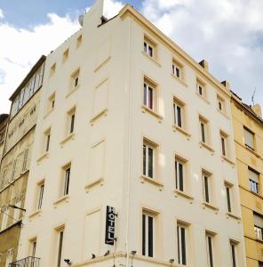 un bâtiment blanc avec un panneau sur son côté dans l'établissement Hôtel Beauséjour, à Marseille