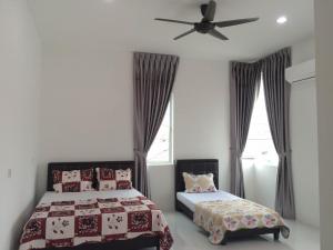 una camera con 2 letti e un ventilatore a soffitto di Sleepee Homestay a Teluk Intan
