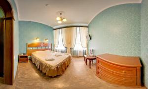 ein Schlafzimmer mit einem Bett und einem Tisch darin in der Unterkunft Hotel Adeliya in Sankt Petersburg