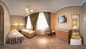 ein Hotelzimmer mit 2 Betten und einem TV in der Unterkunft Hotel Adeliya in Sankt Petersburg