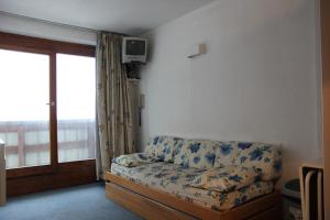 a living room with a couch and a window at Altineige in Val Thorens