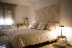 a bedroom with a white bed with a large headboard at Cal Fasi in Torá de Rulbregos +22 photos