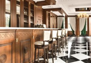 a bar with a row of stools at London Boutique Hotel in Chişinău