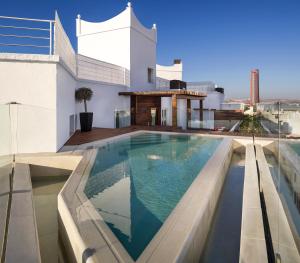 a swimming pool on the roof of a house at Hotel Colón Gran Meliá - The Leading Hotels of the World in Seville