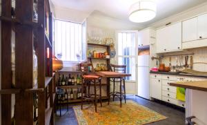 uma cozinha com armários brancos e uma mesa com bancos em Piso con encanto en zona de tapas em Logroño