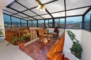 Habitación con balcón con mesa y sillas. en Hotel Yanuncay, en Cuenca