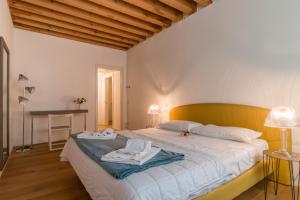 een slaapkamer met een groot bed en 2 handdoeken bij Centrale Mazzoni 10 in Venetië