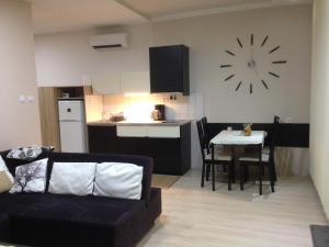 バラトンフレドにあるLUX Apartmanのリビングルーム(ソファ、壁に時計付きのテーブル付)