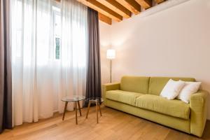 a living room with a green couch and a window at Centrale Mazzoni 10 in Venice