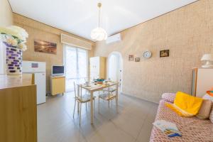 eine Küche und ein Wohnzimmer mit einem Tisch und einer Couch in der Unterkunft Green Marine B16 Silvi Vacanza in Silvi Marina