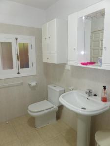 biała łazienka z toaletą i umywalką w obiekcie Cortijillo Violeta w mieście Agua Amarga