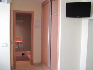 a room with a closet with a flat screen tv at Hostal Ducal in Gandía