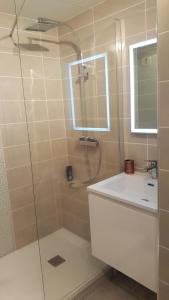 a bathroom with a shower and a sink and a mirror at Appartement T2 valras plage in Valras-Plage