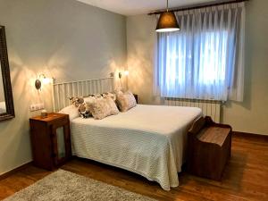 ein Schlafzimmer mit großem Bett und Fenster in der Unterkunft La Aguilerina Apartamentos Rurales in Oviñana