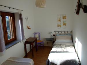 オルヴィエートにあるPodere La Vignaのベッド2台、テーブル、窓が備わる客室です。