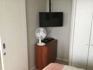 1 dormitorio con ventilador y vestidor con TV en Serena Holiday Vista, en La Serena