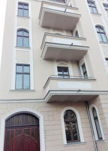- un bâtiment blanc avec des portes et des fenêtres rouges dans l'établissement Starotoruński apartament, à Toruń