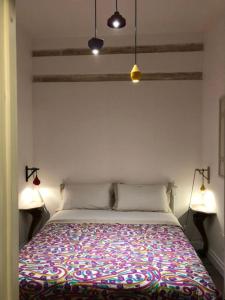ビトントにあるPalazzo Siena De Facendisのベッドルーム1室(カラフルな毛布付きのベッド1台付)
