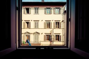 une fenêtre ouverte avec vue sur un bâtiment dans l'établissement Mimì Suite, à Florence