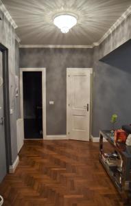 ローマにあるBig Tree Luxury Apartmentのウッドフロアのリビングルーム(白いドア付)