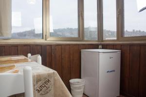 um pequeno frigorífico num quarto com janelas em Mansarda Romantica em Verona