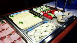 un buffet de comida con queso, carne y verduras en Eurohotel, en Baniocha