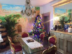 a dining room with a christmas tree on a table at Stanze Barocche in Modica