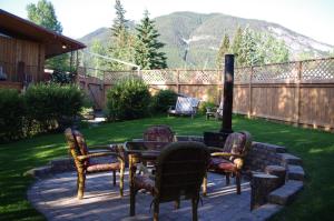 eine Terrasse mit Stühlen, einem Tisch und einem Kamin in der Unterkunft At Wits End B&B in Banff