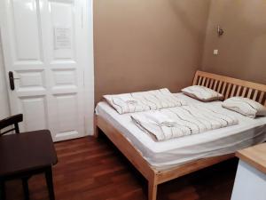 a bed with white sheets and pillows in a room at Market Square Apartment in Budapest