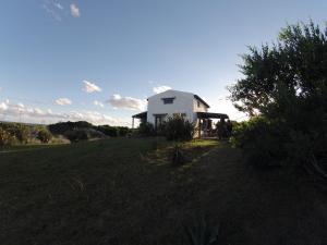 ein weißes Haus auf einem Grasfeld in der Unterkunft El Rancho de arenas de Jose Ignacio in José Ignacio
