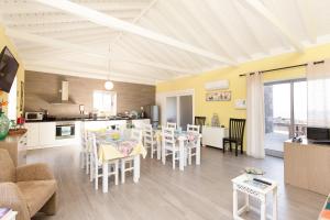a kitchen and living room with a table and chairs at Ocean Breeze in Cais do Mourato