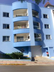 een blauw gebouw met balkons aan de zijkant bij Edifício Summer Ville in Piratuba