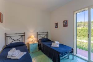two beds in a room with a window at Case Spazioscena - Urania in Finale