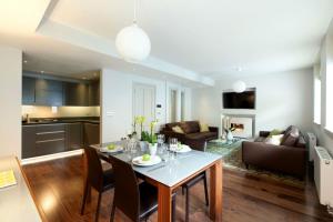 a kitchen and a living room with a table and chairs at AKA Marylebone in London