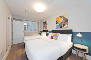 a bedroom with a large white bed and a table at Temple Bar Crown Square Apartments in Dublin