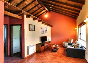 uma sala de estar com um sofá e uma televisão em Apartamentos Rurales "La Torre" y "El Pielago" em Gamones