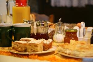 una mesa cubierta con platos de comida y tazas de café en Eleni's Guesthouse, en Palaios Agios Athanasios