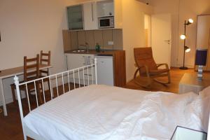 a bedroom with a white bed and a kitchen at Le Relais in Düsseldorf +12 photos