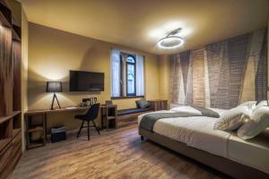 a bedroom with a bed and a desk and a television at 9 stanze - Boutique Rooms in Trieste