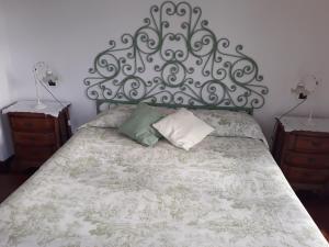 B&B Villa Isabella في إمبيريا: غرفة نوم مع سرير مع اللوح الأمامي والوسائد المعدنية