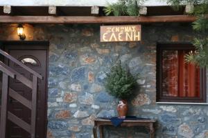 a building with a sign on the side of it at Eleni's Guesthouse in Palaios Agios Athanasios