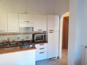 een keuken met witte kasten en een magnetron bij Casa Del Pruno in Monterosso al Mare
