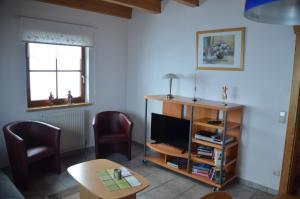 a living room with a tv and two chairs and a table at Haus Gaby Stöckl in Rauris