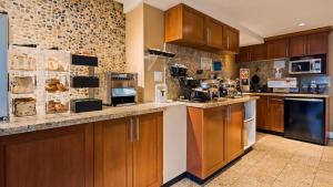 a kitchen with wooden cabinets and a stone wall at Best Western PLUS Inner Harbour Hotel in Victoria